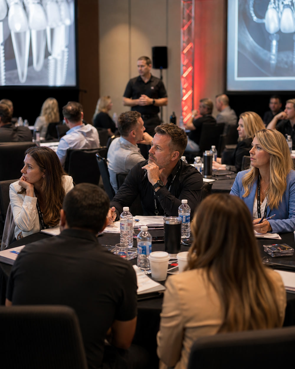 Dental practice teams learning full-arch case acceptance in a live boot camp room